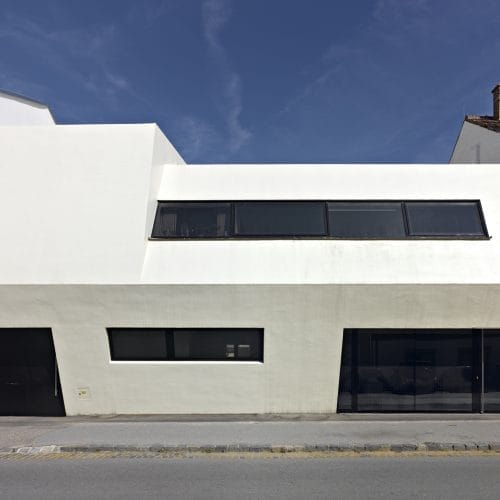 lostinarchitecture_BUR_ White Monolith_Ordination und Wohnhaus. Straßenansicht als bewußter Kontrast zur undefinierten Umgebung. Arztpraxis und abgeschottetes Wohnhaus mit Garten