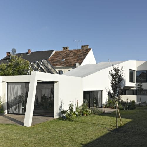 lostinarchitecture_BUR_ White Monolith_Ordination und Wohnhaus mit Garten mitten in der Stadt. Hier der Blick vom Garten auf das Gebäude, wo die totale Privatssphäre spürbar ist.