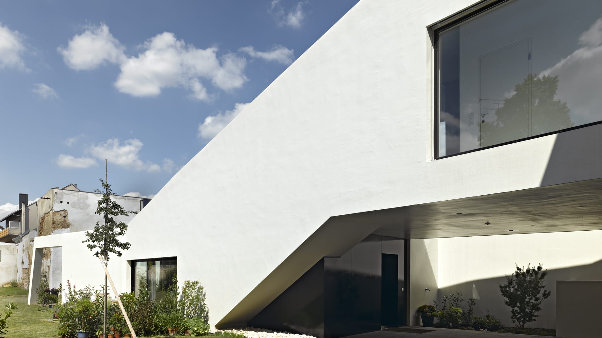 lostinarchitecture_BUR_ White Monolith_Eingangsbereich mit Brückentrakt und Blick zum städtischen Garten