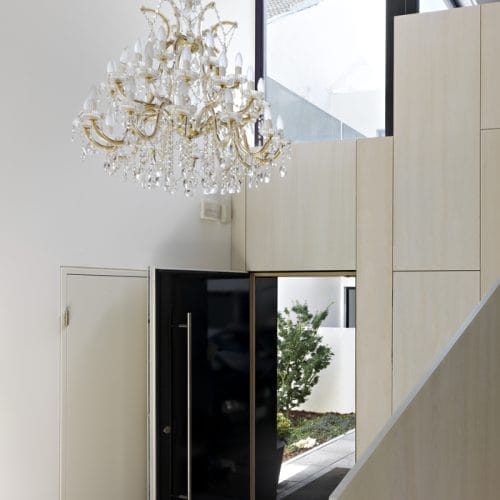 lostinarchitecture_BUR_Weißer Monolith_Eingangsbereich mit weiß lasiertem Echtholz mit Blick zum Atrium Kontrast Weiß/ Schwarz